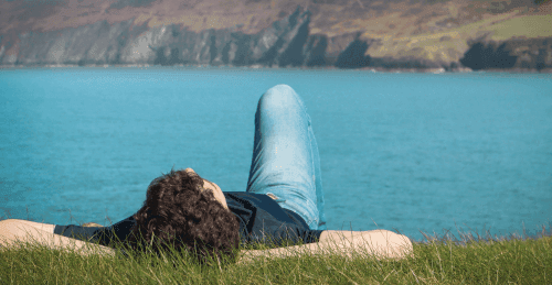 A guy daydreaming in front of the ocean