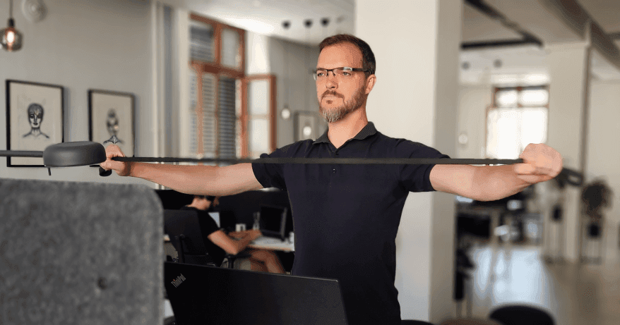 A man doing pull-apart workout in office